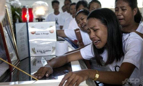 フィリピン・パラワン島のエルニドで、殺害された環境保護団体パラワンNGOネットワーク・インコーポレーテッド（PNNI）のメンバー、ルベン・アルザガさんのひつぎにすがって泣く、アルザガさんの娘