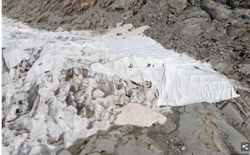 氷河を防水布で覆う作業。手作業で布を広げていく。ローヌ氷河で。