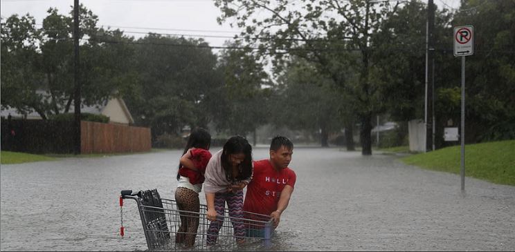 子どもをショッピングカーに入れて避難するヒューストンの住民（27日）