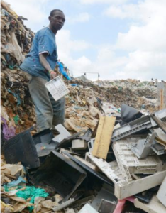 ケニア・ナイロビのごみ集積場で電話機を手にする男性＝２０１４年６月（共同）