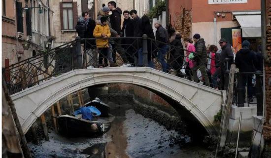 観光客も、運河が干上がったのでびっくり（ベネチアで：Guardian紙）