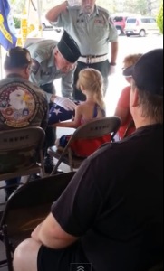 ガンで死亡した父を讃える名誉の星条旗を受け取るロナルド・レーガンの乗組員の娘