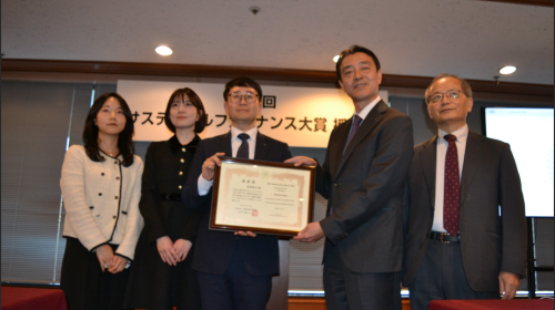 表彰状を受け取るイ氏㊥、㊨は審査員の高田英樹氏、藤井良広。㊧は新韓銀行日本の関係者ら