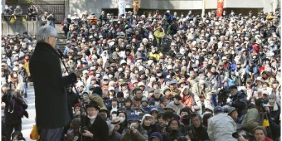 東京・日比谷野外音楽堂で開かれた脱原発の大規模集会。左手前はスピーチする坂本龍一さん＝９日午後