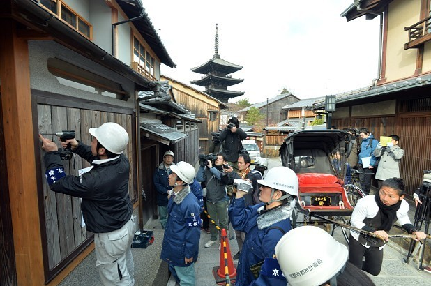 窓（左）に板を打ちつけてふさぐ京都市職員ら。中央奥は八坂の塔＝京都市東山区で２０１４年１２月１０日午前１０時１１分、森園道子撮影