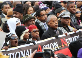 １３日、米ワシントンで行われた抗議デモで横断幕を掲げる黒人運動指導者シャープトン師（手前右から２人目）（共同）