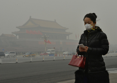 スモッグが垂れ込める北京（Beijing）市内の天安門広場（Tiananmen Square）近くをマスク姿で歩く女性（2014年2月26日撮影、資料写真）。(