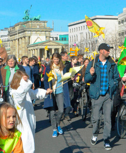 ８日、ベルリンのブランデンブルク門近くを歩くデモ参加者＝共同