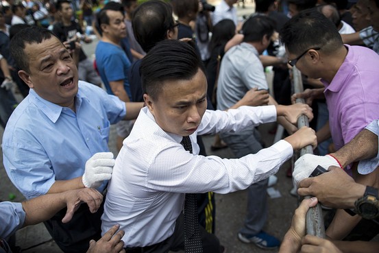 路上のバリケードをめぐりもみ合う民主化デモ隊とデモに反対する人々（13日） Reuters