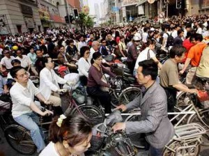 自転車、電動自転車、モペット（原動機つき自転車）で通勤、通学する人々（中国、上海で2008年撮影）。
