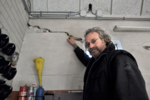 ひびの入った壁を示す住民