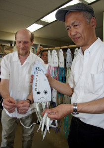 「イカイカ募金」で大間原発建設差し止め訴訟を応援する高橋泰助代表（右）と呼びかけ人のピーター・ハウレットさん