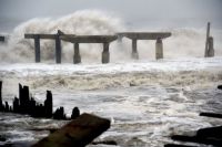 Waves crash against a previously damaged pier before landfall of Hurricane Sandy in Atlantic City