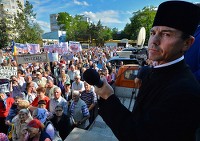 ルーマニア東部ブルラド（Barlad）市で行われたシェールガス採掘に反対する集会で祈りを捧げる正教会ブルラド教区主席司祭バシリー・ライウ（Vasile Laiu）神父（2013年5月27日撮影）。 ©AFP＝時事