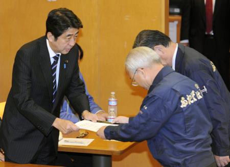 福島第１原発周辺の首長らから提出された要望書を受け取る自民党の安倍総裁（左）＝３日夕、福島県楢葉町のＪヴィレッジ
