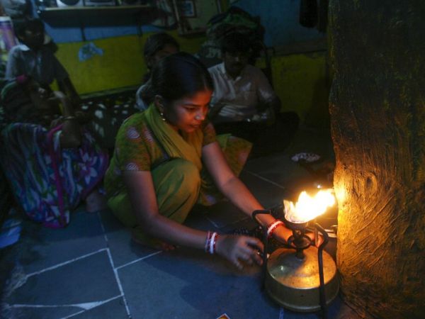 小さな家の中で料理をする女性。インド、ムンバイで。