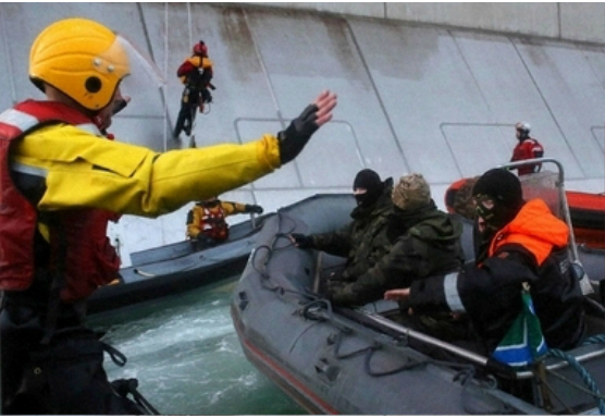 北極圏のペチェラ海（Pechora Sea）で、ロシア国営エネルギー大手ガスプロム（Gazprom）所有の石油プラットホームによじ登ろうとする国際環境保護団体グリーンピース（Greenpeace）の活動家たちに、ゴムボートで接近するロシアの沿岸警備隊（右、2013年9月18日撮影）