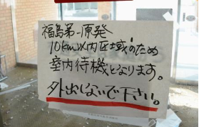福島県双葉町役場の出入り口に張られたままの「外出しないでください」と書かれた紙＝９日