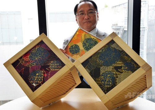アジサイの花をデザインした太陽光発電試作品を手にする東京大学の瀬川浩司教授