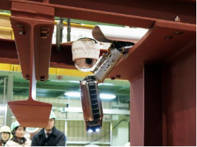　実験用の配管から出る格納容器調査用のロボット＝５日午後、茨城県日立市の日立ＧＥニュークリア・エナジー臨海工場