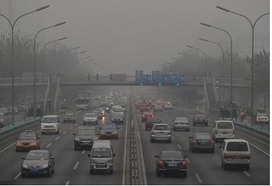 スモッグでかすむ中国・北京（Beijing）市内を走る自動車（2011年12月5日撮影）。(c)AFP/Mark RALSTON