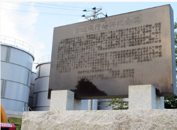 東京電力福島第１原発の構内にある磐城飛行場跡地を示す石碑。周囲は事故後に設置された汚染水のタンクが取り囲む（東京電力提供）