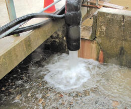 地下水バイパス計画で、配管から海につながる排水溝に流れる地下水＝２１日午前１０時４０分ごろ、福島第１原発４号機の南側（東京電力提供）