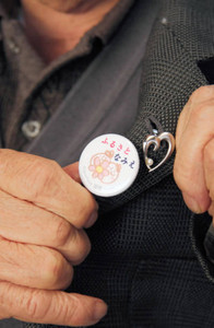 故郷、福島県浪江町のバッジを着ける男性。１１日の提訴でも身に着ける（白名正和撮影）