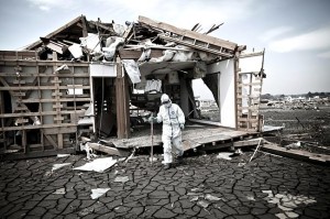 津波で崩壊した浪江町の住宅を捜索する人