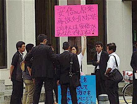 私服警官らしき男性たちに取り囲まれる主婦