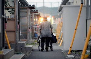 不自由な足を気遣いながら仮設住宅の敷地を歩く高齢の女性。大震災から３年半。長期化する避難ストレスが高齢者の心身に影響を与えている＝１０日夕、宮城県岩沼市で