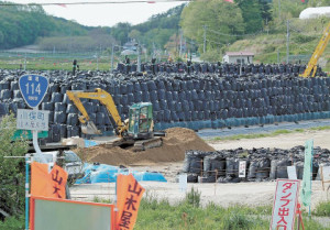 ピラミッド状に積まれた除染廃棄物の山。避難住民は、除染の進み具合を複雑な思いで見詰めている＝福島県川俣町山木屋地区