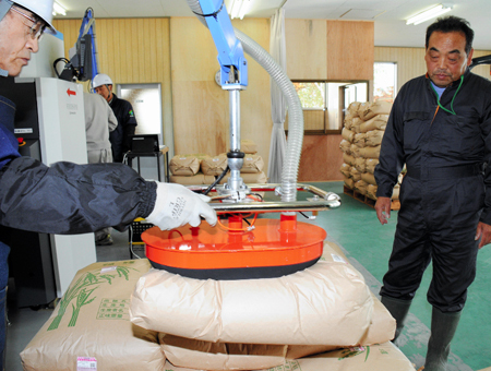 試験栽培のコメを袋ごと放射性検査する。100ベクレルを下回れば出荷可能の認定