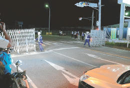 国道６号の通行規制が解除され、ゲートを開ける作業員＝１５日午前０時、福島県富岡町