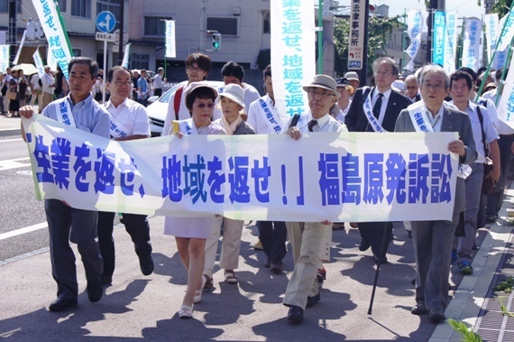 裁判所に向かって行進する、原告と支持者たち