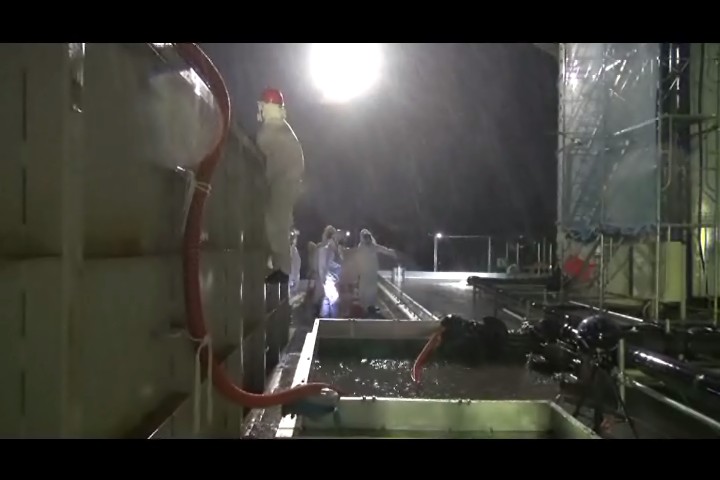 タンクからの排水をチェックする作業員