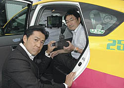 タクシーで線量を測定するシステムを開発した西條社長（左）と斎藤社長