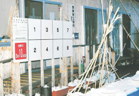 仮設住宅に設置された双葉町長選のポスター掲示板。立候補予定者が多く、スペースを広げた＝福島市