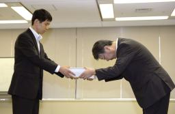 　泊原発１～３号機の再稼働に向け原子力規制委員会の市村知也安全規制管理官（左）に安全審査の申請書を手渡す北海道電力の酒井修副社長＝８日午前、東京都港区