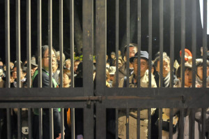 入場制限がかけられ中に入れなかった人々は、身を乗り出すようにして国会議員の演説を聞いた。＝21日午後6時過ぎ、日比谷野音　写真：島崎ろでぃ＝