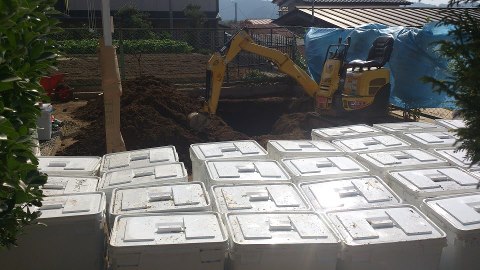 除染後の庭に置かれた汚染土梱包のプラスチックケースの山