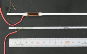 上がコイルを巻いた状態の振動発電装置。下がコイルを除いた状態で、ひも状の電線の先が磁歪材