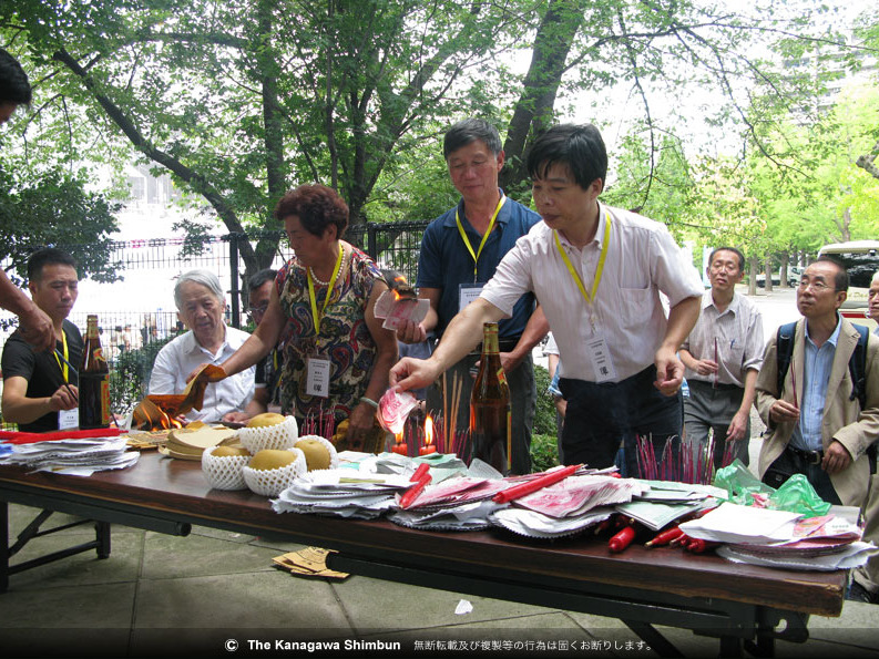 紙銭に火をつけて虐殺された先祖を弔う中国人遺族ら＝東京都江東区の横網町公園