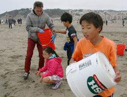 １５日、米西部サンフランシスコのオーシャンビーチで、海岸の一斉清掃に参加した日本人家族（共同）