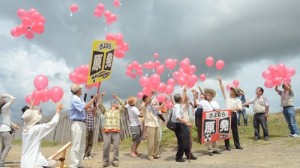赤い風船を大空へ放つ参加者たち＝静岡県御前崎市の白羽海岸で２０１２年８月１８日午前１０時４０分、荒木涼子撮影