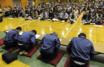 被災住民への説明会で頭を下げる東電関係者