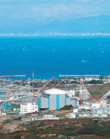 建設が進む大間原発。津軽海峡を挟んだ対岸に函館の街並みが浮かぶ＝２０１２年１０月、青森県大間町