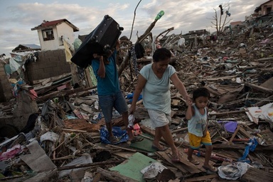 フィリピンのタクロバン（Tacloban）で、破壊された自宅跡で所持品を集める被災者たち（2013年11月19日撮影）。(c)AFP/Nicolas ASFOURI