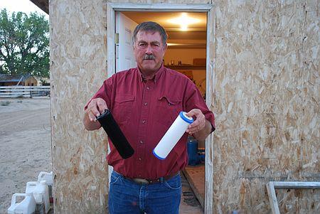汚染水で黒くなったという水フィルターを見せる農民（２００９年９月１７日、米ワイオミング州）