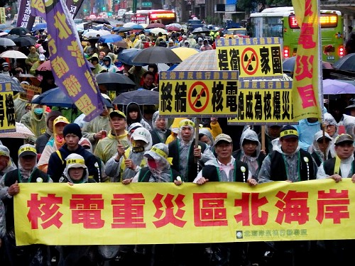 雨の中、反原発を訴えデモ行進する参加者たち＝台北市内で２０１４年３月８日、鈴木玲子撮影